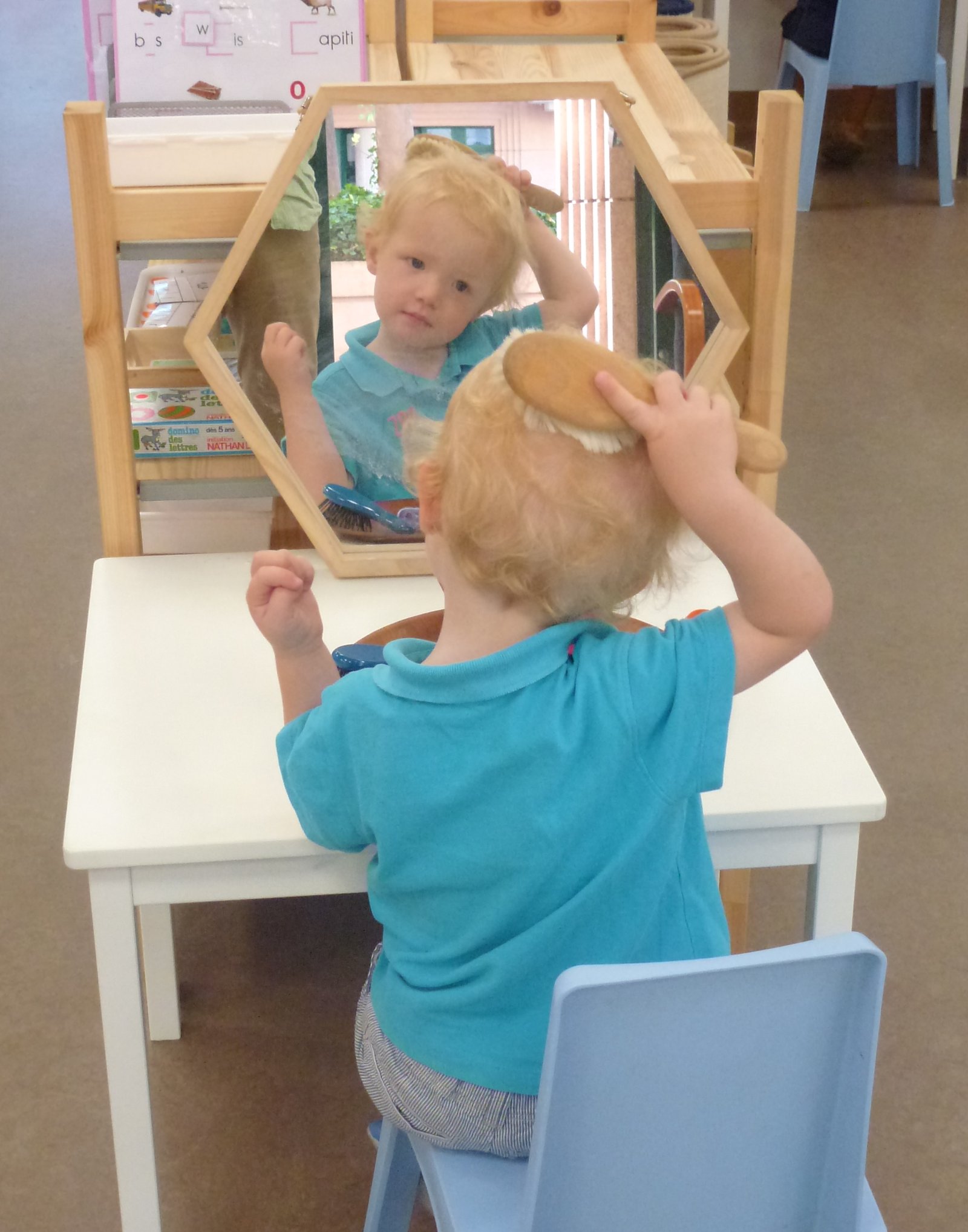 Child hanging a blue coat