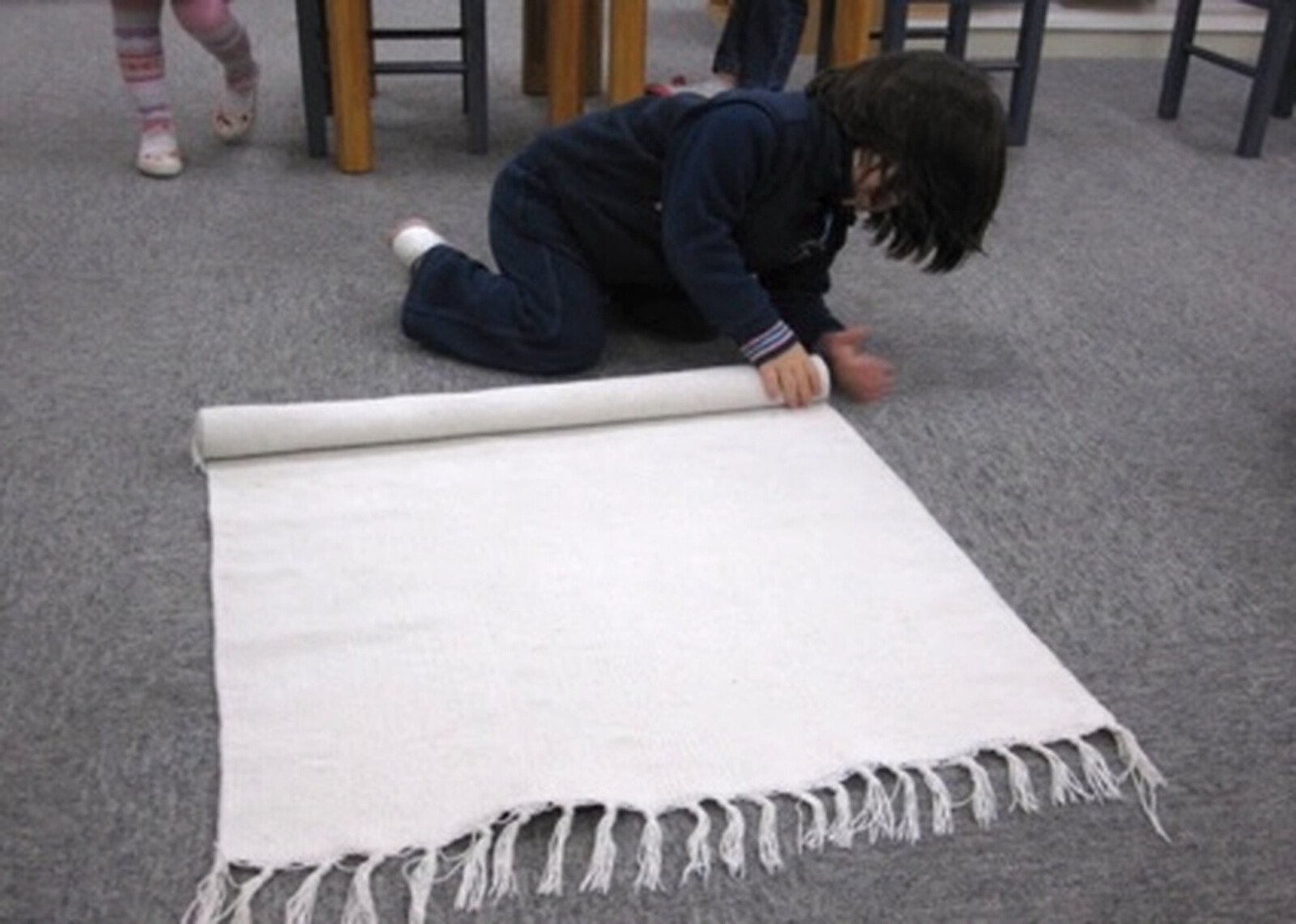 Child rolling a mat